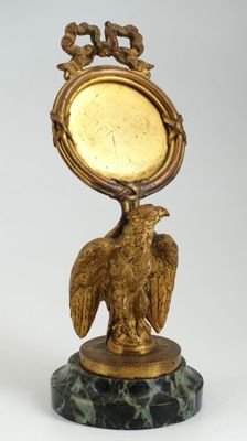 une statue représentant un aigle avec une horloge sur la tête