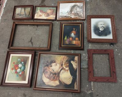 many framed pictures on the floor of this room