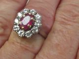 la main d'une femme tenant une bague sertie d'un rubis