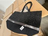 un sac noir et argent posé sur une boîte en carton