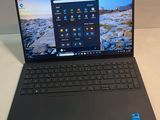 un ordinateur portable ouvert posé sur une table, à côté d'un clavier