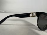 black sunglasses with gold details on a white surface