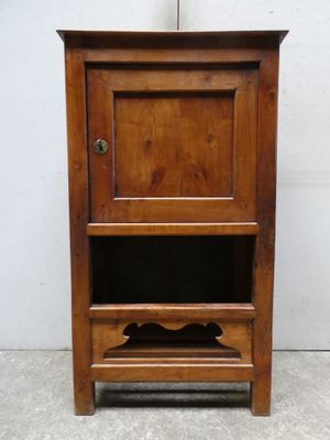 an old wooden cabinet with a door and a shelf on top of it