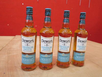 Quatre bouteilles de Dewvar's sont alignées sur une table