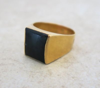 an image of a gold ring with a black stone