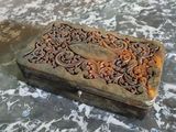 une petite boîte en bois ornée de sculptures, posée sur une table