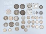 an assortment of silver and silver coins on a white surface
