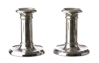 une paire de bougeoirs en argent sur fond blanc, avec un fond blanc