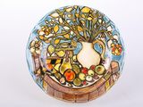 a plate with a vase of flowers and fruit on it