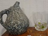 a vase and a glass on a table next to each other