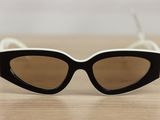 black and white cat eye sunglasses sitting on a wooden table