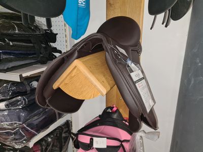 un sac à dos rose et une selle marron dans un magasin