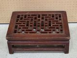 a small wooden table with a lattice design on it