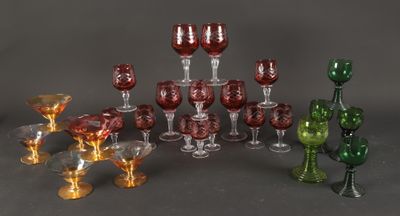 many different colored glasses and vases sitting on a table