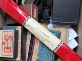 une boîte en carton remplie de livres et une batte de baseball rouge