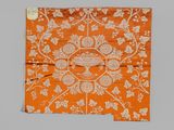 un motif floral orange et blanc sur un morceau de tissu