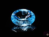 gros plan d'un diamant bleu sur une surface noire