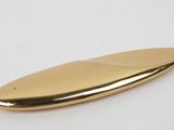 a close up of a gold surfboard on a white surface