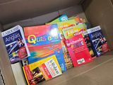 une boîte remplie de livres posés sur le sol