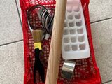 un panier rouge rempli d'outils posé sur un sol carrelé