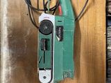 un outil électrique vert et noir posé sur une table en bois