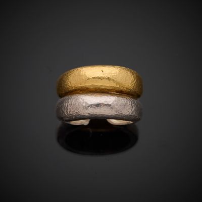 a close up of a gold and silver ring on a black surface