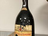 une bouteille de vin posée sur une table à côté d'une lampe