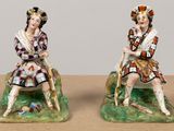 pair of figurines of a man and a woman sitting on a bench