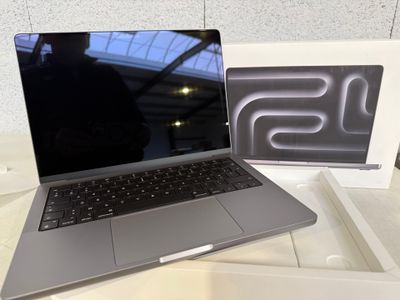 un ordinateur portable ouvert posé sur une table, à côté d'une boîte