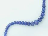 a picture of a strand of blue beads on a white surface