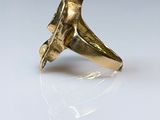 a close up of a gold ring on a white surface