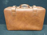 a brown leather suitcase sitting on a blue surface