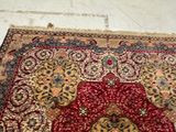 an image of a red and yellow area rug on a white floor