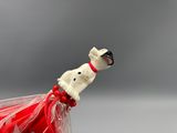 a small figurine of a dog in a red dress