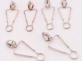 six silver spoons and a pair of tonges on a white surface