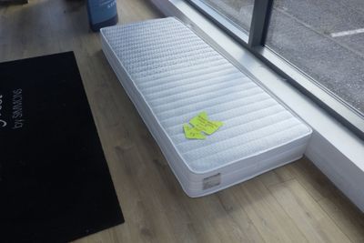 un matelas posé à même le sol près d'une fenêtre
