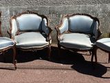quatre chaises anciennes sont alignées contre un mur en béton