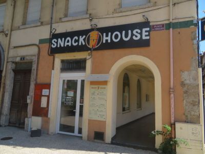 une enseigne indiquant « Snack House » sur la façade d'un immeuble