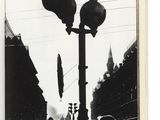 une photo en noir et blanc représentant un lampadaire et une foule de gens