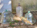 trois cloches en verre posées par terre les unes à côté des autres