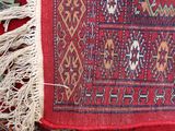 a close up of a red rug with fringes on it