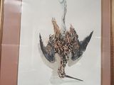 une photo d'une photo représentant un oiseau accrochée au mur