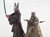 two figurines of star wars characters are posed on a white surface