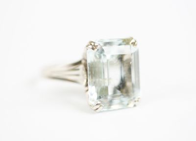 a close up of a ring with an aquamarine stone in it