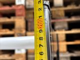 a measuring tape on a pole in front of a pile of pallets