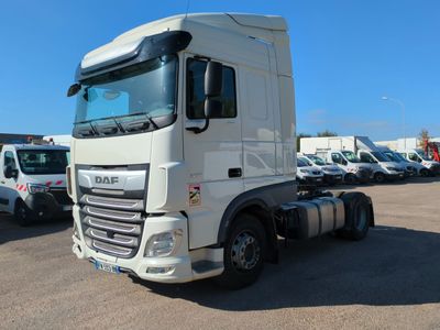 un camion blanc garé sur un parking avec d'autres camions