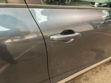 a close up of a car door handle with a bike in the background