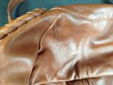 a close up of a brown leather purse on a table