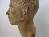 marble bust of a man in profile on display in a glass case