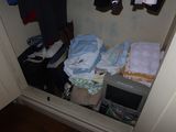 a small closet with clothes and other items in it